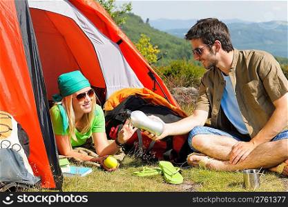 Happy camping couple with tent backpack in sunny countryside
