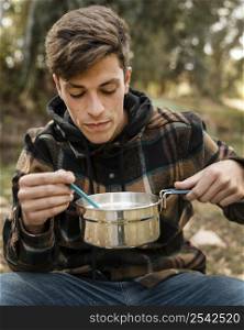 happy camping man forest eating from pot