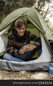 happy camping man forest using mobile phone