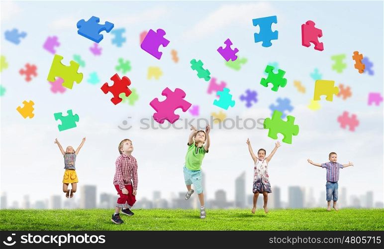 Happy careless childhood. Group of children jumping high joyfully on colorful background