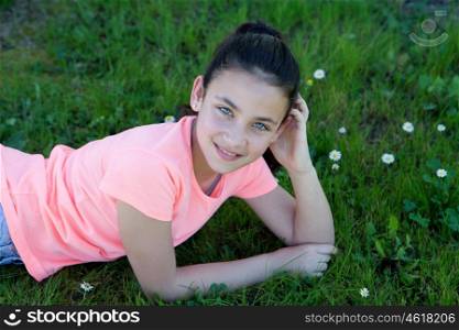 Happy casual preteen girl lying in the grass