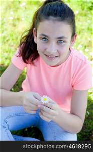 Happy casual preteen smelling a daisy at outside