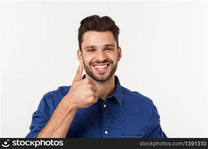 Happy casual young man showing thumb up and smiling isolated on white background. Happy casual young man showing thumb up and smiling isolated on white background.