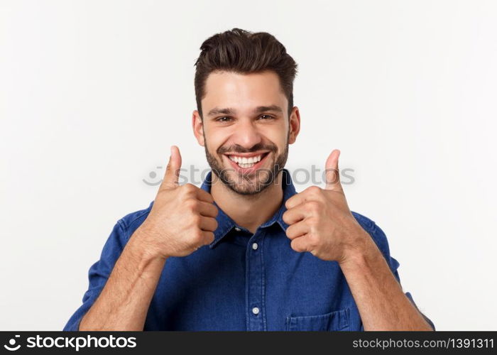 Happy casual young man showing thumb up and smiling isolated on white background. Happy casual young man showing thumb up and smiling isolated on white background.