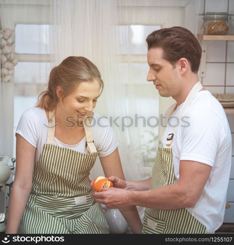 Happy caucasian couple family cooking in modern kitchen at home with love. Married romantic man and woman cooking fresh vegetable salad.Healthy lifestyle concept.