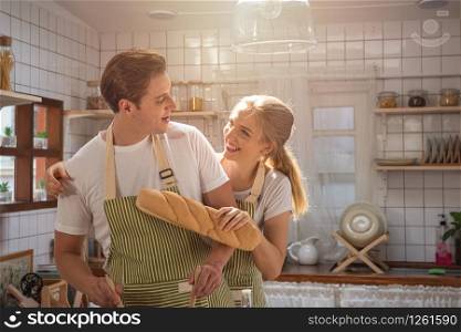 Happy caucasian couple family cooking in modern kitchen at home with love. Married romantic man and woman cooking fresh vegetable salad.Healthy lifestyle concept.