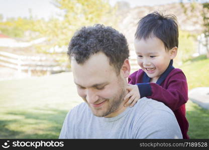 Happy Caucasian Father Having Fun with His Mixed Race Baby Son.