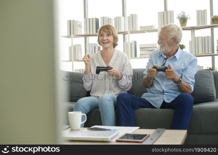 Happy Caucasian senior couple playing games at home