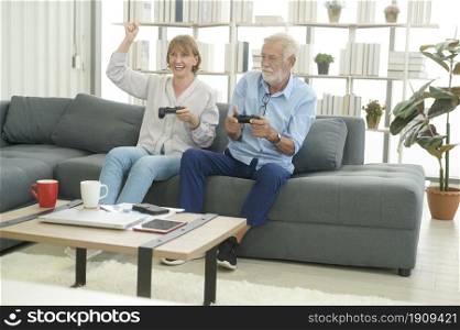 Happy Caucasian senior couple playing games at home