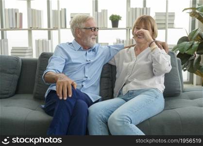 Happy Caucasian senior couple relaxing in living room at home