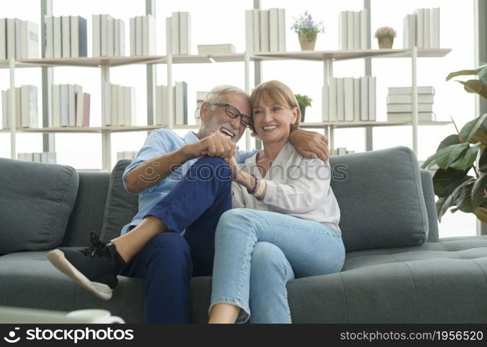 Happy Caucasian senior couple relaxing in living room at home