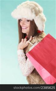 Happy charming gorgeous woman with bag shopping. Young girl in fur hat in studio blue. Winter fashion clothes sale.. Happy woman with bag shopping. Winter fashion.