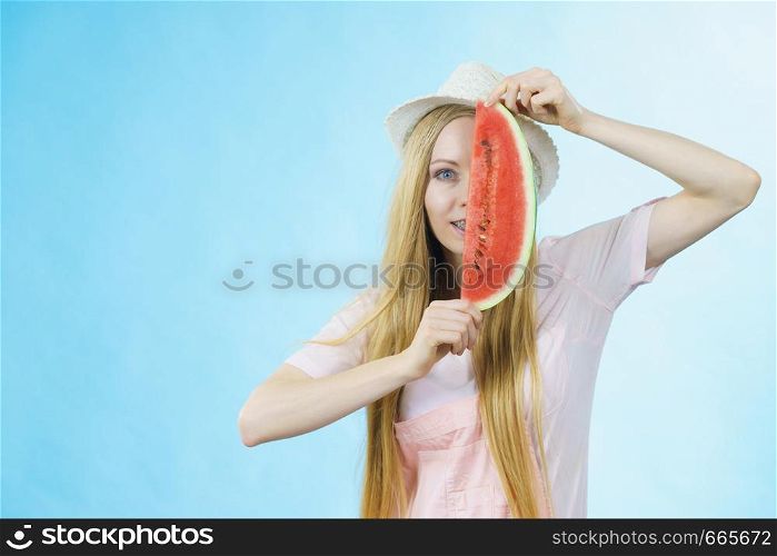 Happy cheerful teenage girl ready for summer wearing sun hat holding sweet fruit red juicy watermelon, on blue. woman holding watermelon fruit