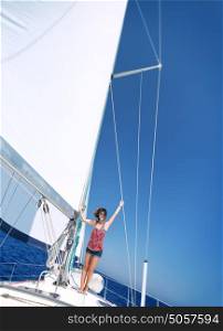 Happy cheerful woman having fun on sailboat in sunny day, enjoying summer adventure in sea cruise, active summertime vacation