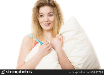 Happy cheerful woman wearing blue pajamas holding pillow and toothbrush. Isolated background.. Happy cheerful woman wearing pajamas