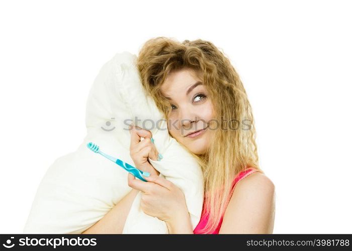 Happy cheerful woman wearing pajamas holding pillow and toothbrush. Isolated white background.. Happy cheerful woman wearing pajamas