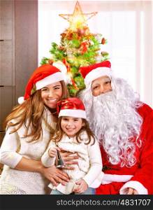Happy cheerful young family celebrate Christmas holiday at home, little girl with mother and father wearing Santa Claus costume