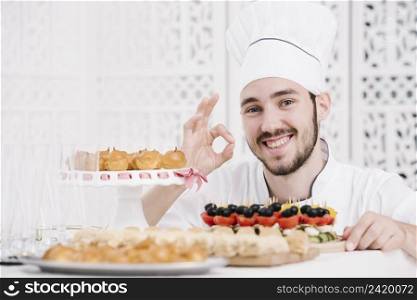 happy chef presenting food table