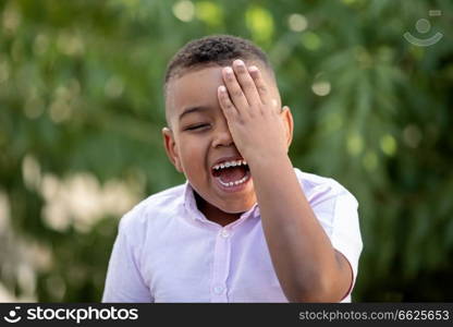 Happy child covering his eye in the park