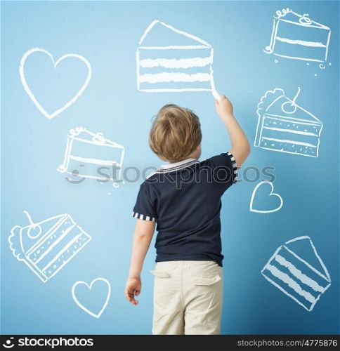 Happy child drawing sweets with chalk