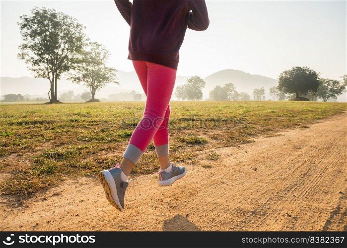 happy child girl running on meadow in summer in nature. warm sunlight flare. asian little is running in a park. outdoor sports and fitness, exercise and competition learning for kid development.