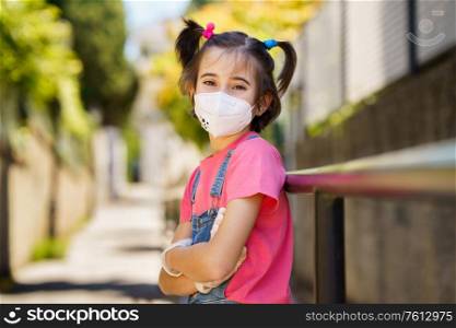 Happy Child girl wearing a protection mask against coronavirus during Covid-19 pandemic. KN95 mask.. Child girl wearing a protection mask against coronavirus during Covid-19 pandemic
