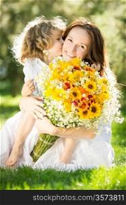 Happy child giving big bouquet of spring flowers to woman for mother`s day