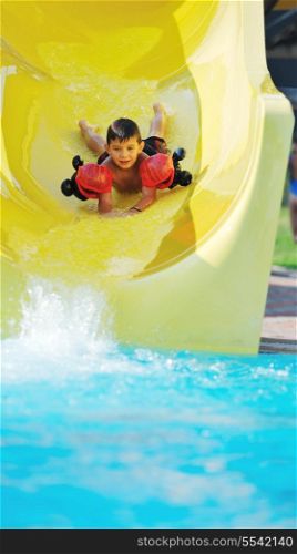 happy child have fun on water slike on outdoor swimming pool