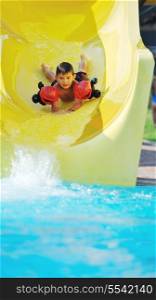 happy child have fun on water slike on outdoor swimming pool