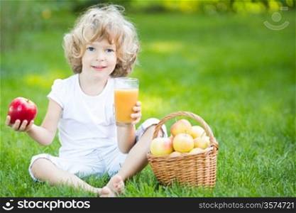 Happy child having picnic outdoors in spring park