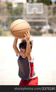 Happy child holding basketball, outdoors