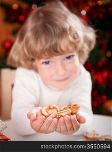 Happy child holding cookies against Christmas lights background