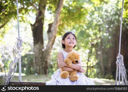 Happy Child hug teddy bear in green park playground. Teddy bear best friend for little kids cute girl. Autism happy funny playing together on playground in happiness family feel love and warm hugs