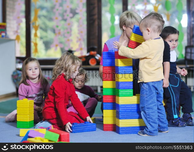 happy child kids group have fun and play at kindergarden indoor preschool education concept with teacher