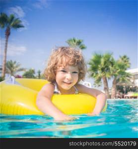 Happy child playing in swimming pool. Summer vacations concept