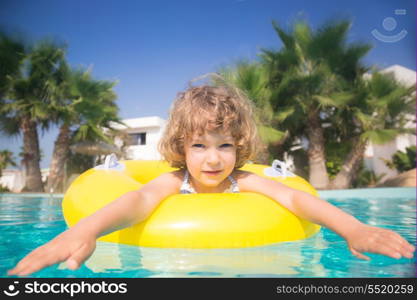 Happy child playing in swimming pool. Summer vacations concept