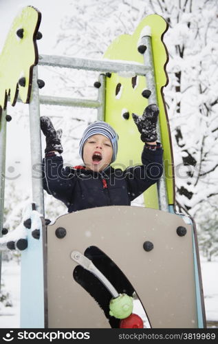 happy child playing in the snow day in the park