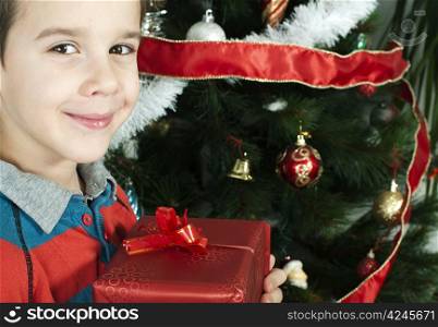 Happy child receive the gift of Christmas in front of the Christmas tree.