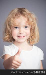 Happy child showing thumbs up sign