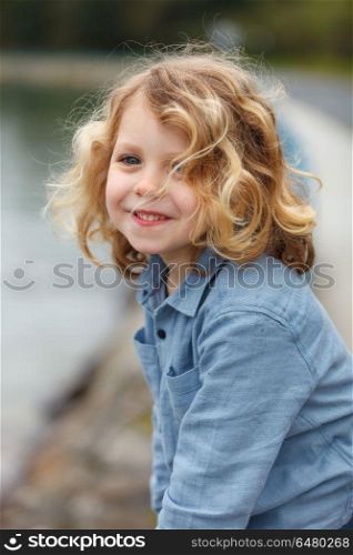 Happy child with long blond hair enjoying the holidays. Happy small child with long blond hair enjoying the holidays