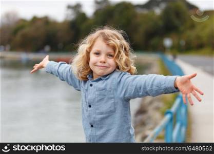 Happy child with long blond hair enjoying the holidays. Happy small child with long blond hair enjoying the holidays