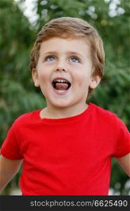 Happy child with red t-shirt playing in the garden 