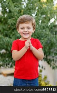 Happy child with red t-shirt playing in the garden 