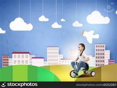 Happy childhood. Cute girl against drawn background riding three wheeled bike