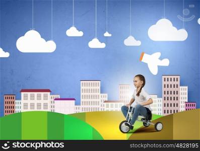Happy childhood. Cute girl against drawn background riding three wheeled bike