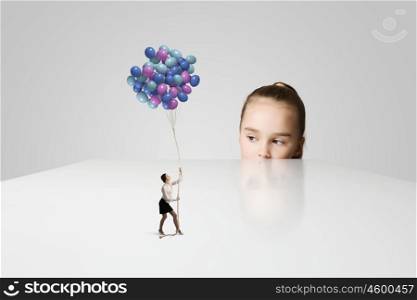 Happy childhood. Little cute girl and woman with bunch of colorful balloons