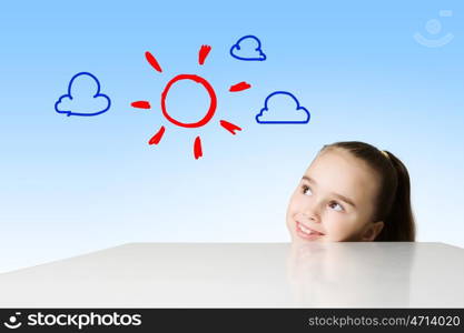 Happy childhood. Little cute girl looking at drawing of sun