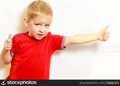 Happy childhood. Portrait of smiling funny blond boy child kid preschooler showing thumb up success hand sign gesture. Indoor.