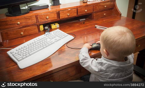 Happy childhood. Smart little boy child kid playing on the desktop computer at home. Technology.