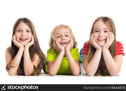 Happy children isolated on white. Happy smiling three children in colorful clothes laying on floor isolated on white background